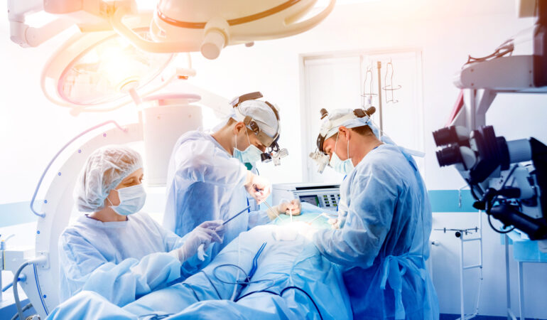 Spinal surgery. Group of surgeons in operating room with surgery equipment. Laminectomy. Modern medical background